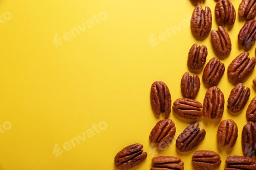 Preview: Tasty pecan nuts on yellow background, flat lay. Space for text