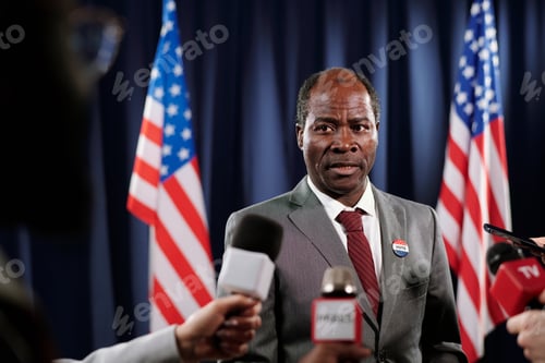Preview: Mature male deputy looking at one of journalists during interview