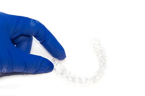 Preview: Orthodontist holds clear teeth aligners. Invisible braces teeth straighteners. Clear plastic bracers