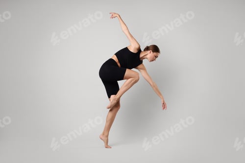 Preview: Woman doing gymnastic exercise on light grey background