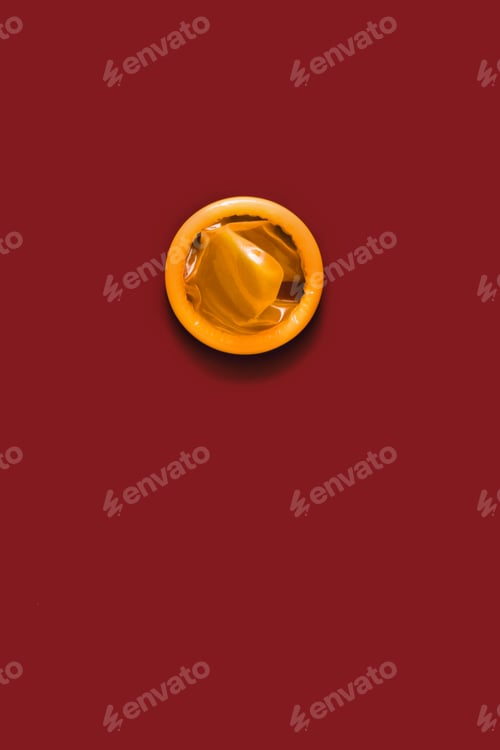 Preview: Golden color condom on red background