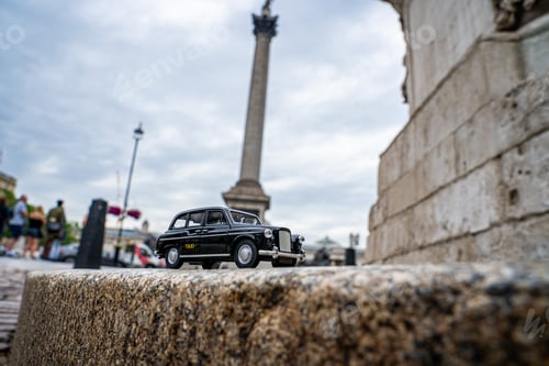 Preview: Closeup shot of a traditional black cab driving through the most famous landmarks in London