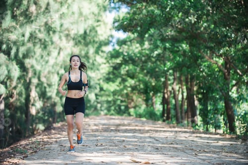Preview: Young fitness woman jogging in park.