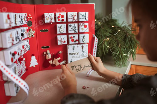 Preview: Pretty girl holds original advent calendar made of jewelry boxes and binder, Christmas diy craft