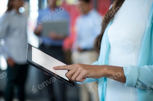 Preview: Mid section of businesswoman using digital tablet
