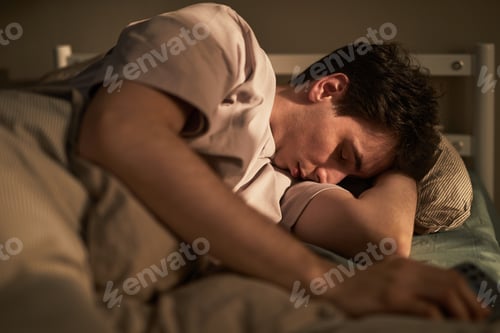 Preview: Young Caucasian Man Sleeping Peacefully in Bed Showing Calm Emotion