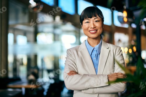 Preview: Portrait of an Asian female restaurant manager, dressed elegantly, smiling for the camera.
