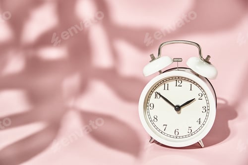 Preview: White alarm clock and leaves shadows on pastel pink background