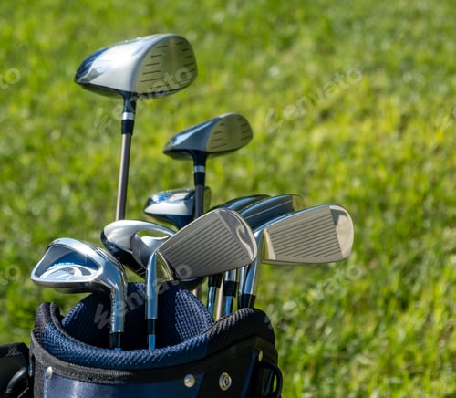 Preview: Golf sticks on green grass golf course, close up view.