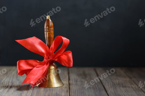 Preview: back to school background. hand bell on first of September on blackboard background