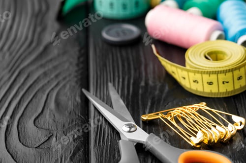 Preview: Colorful sewing utensils on black wooden surface