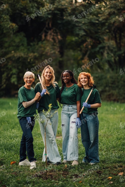 Preview: Four volunteers posing together after planting a tree