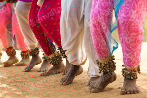 Preview: Low section view of barefoot dancers in a row on a street, wearing pink trousers and ankle bells.