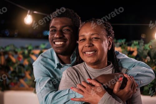 Preview: Mother and son hugging on the terrace of their house at a family celebration. Concept: bond, fun