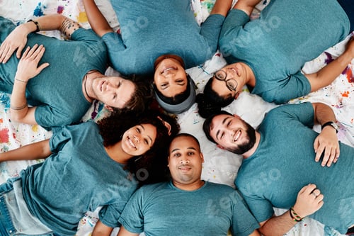 Preview: High angle portrait of a diverse group of friends lying down in a circle during an art class