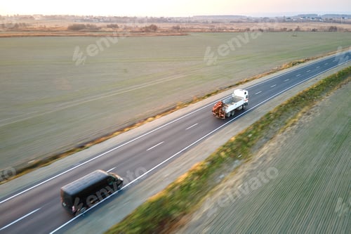 Preview: Aerial view of intercity road with fast driving cars at sunset.