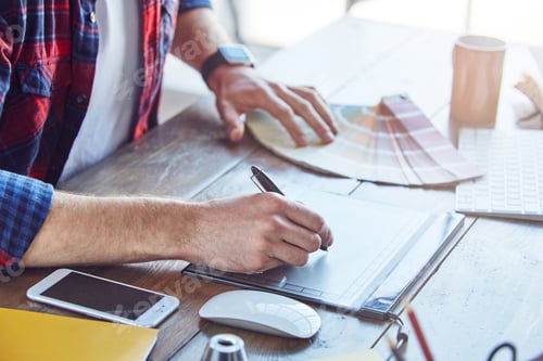 Preview: Man drawing new project choosing color samples in modern creative studio