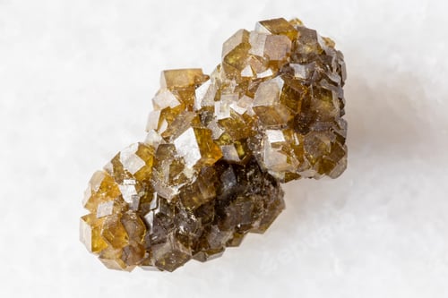 Preview: raw druse of andradite garnet crystals on white