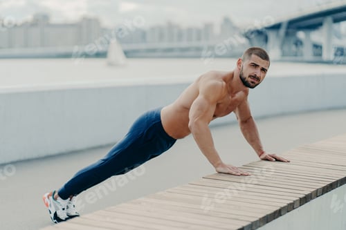 Preview: Fit muscular man does plank push up exercise leads healthy lifestyle wears sport trousers