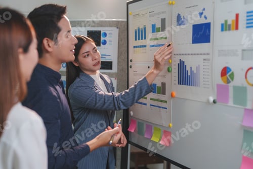 Preview: Businesswoman presenting business data on whiteboard to colleagues