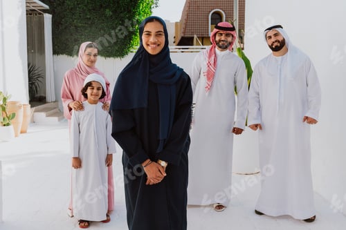 Preview: Emirati family standing together smiling in traditional attire