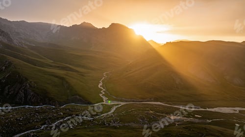 Preview: Golden sunset illuminates a vast mountain river valley