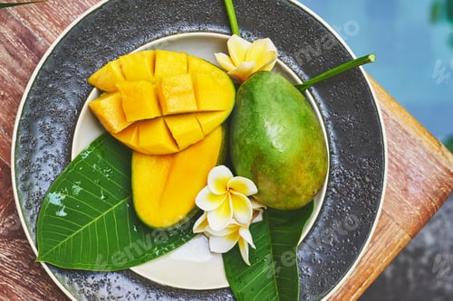 Preview: Fresh mango on a wooden tabel with tropical background. Soft focus.