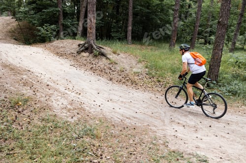 Preview: Mountain biker riding on bike in spring inspirational mountains landscape. Man cycling MTB on enduro