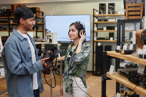 Preview: Black young man working in music store and listening to music with headphones