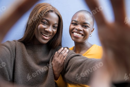 Preview: Casual street portrait of two Black women enjoying a selfie moment together