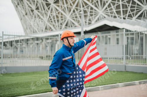 Preview: a patriontic american male worker holding usa national flag outdoors