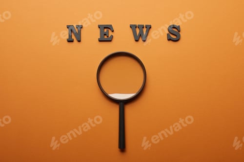 Preview: top view of news lettering near magnifying glass on orange