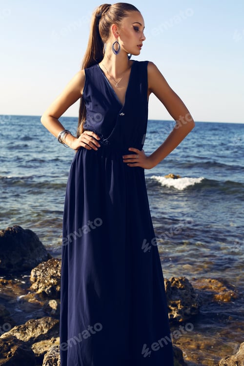 Preview: Fashion Outdoor Photo Of Beautiful Woman With Long Hair In Elegant Blue Dress Posing Beside A Sea