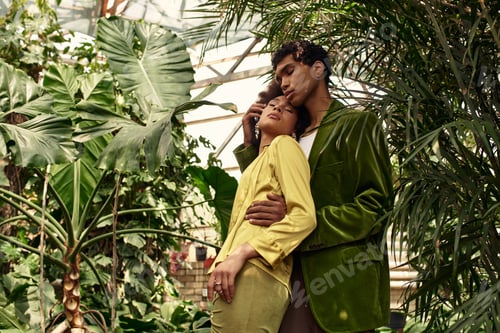 Preview: Young couple shares a tender moment amidst lush greenery in a serene greenhouse setting