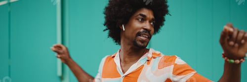 Preview: man wearing shirt listening to music in wireless headphones and dancing