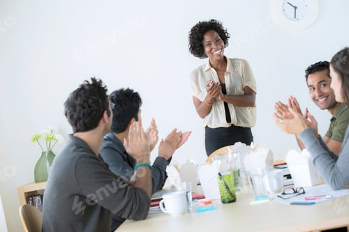 Preview: A group of coworkers applauding a presentation in a modern office setting.