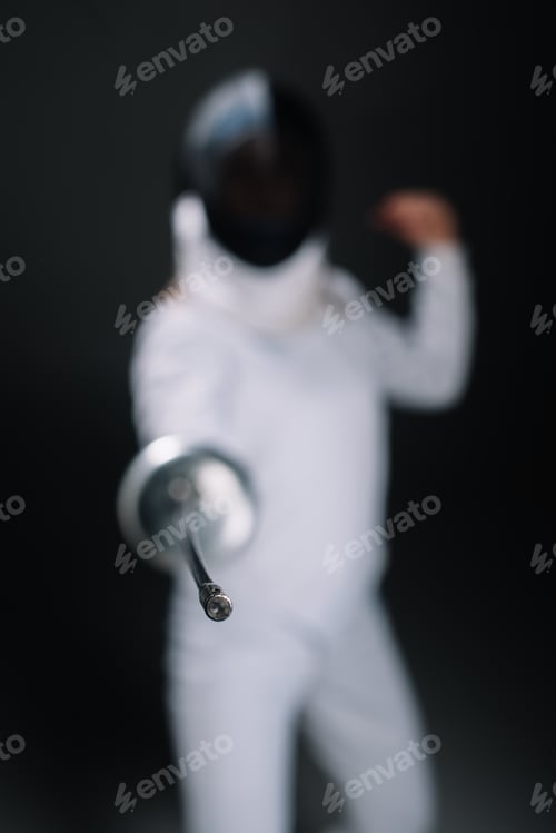 Preview: Selective focus of fencer holding rapier isolated on black