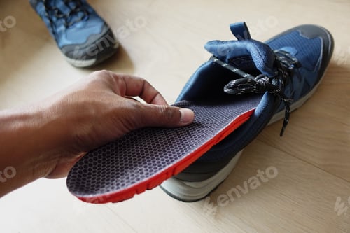 Preview: men hand putting Orthopedic insoles in shoes