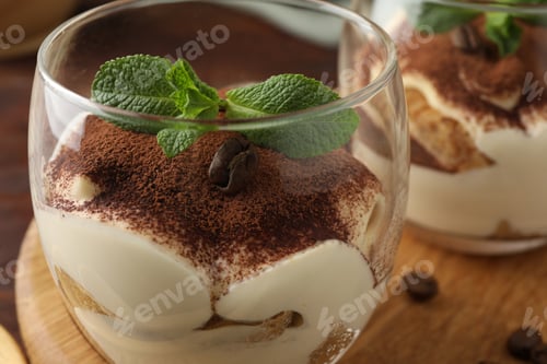 Preview: Delicious tiramisu in glasses, mint leaves and coffee beans on table, closeup