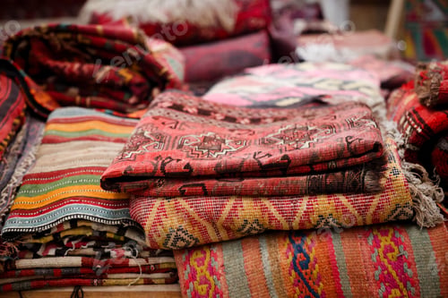 Preview: Colorful Pile of Uzbekistan National Souvenir Blankets on Wooden Floor