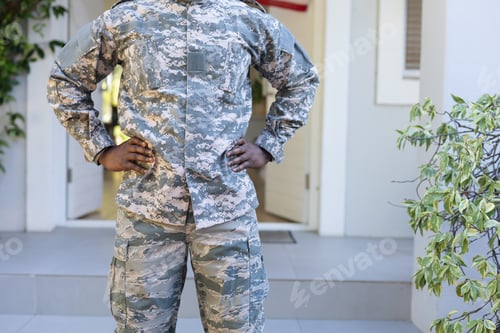 Preview: Adult in Military Uniform Stands in Front of House