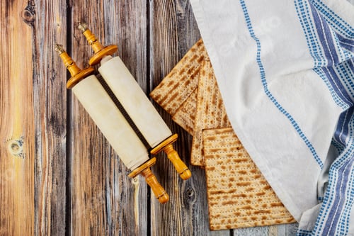Preview: Top view of matzah, tallit and torah on wooden background.