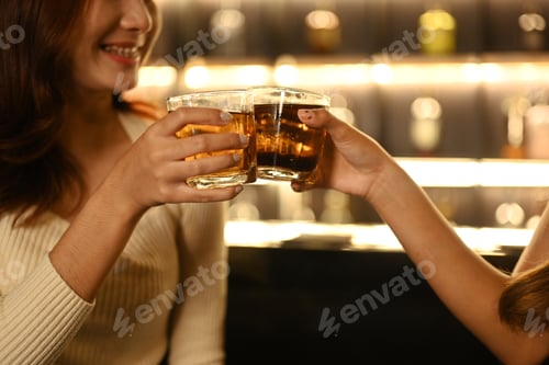 Preview: Close up shot of two friends toasting with drinks in the bar. Nightlife concept