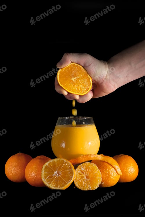 Preview: Hand squeezing oranges into drinking glass
