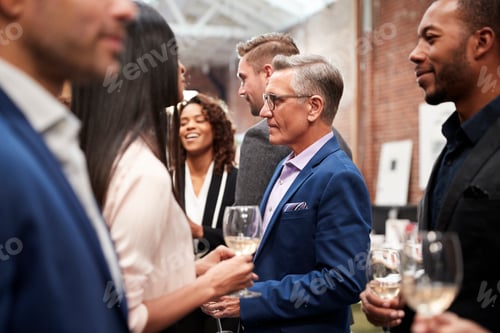 Preview: Business Team Socializing At After Works Drinks In Modern Office