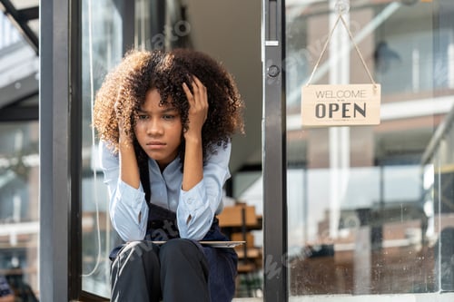 Preview: black woman waiter of street cafe is waiting for clients, customersm she is bored, no people in