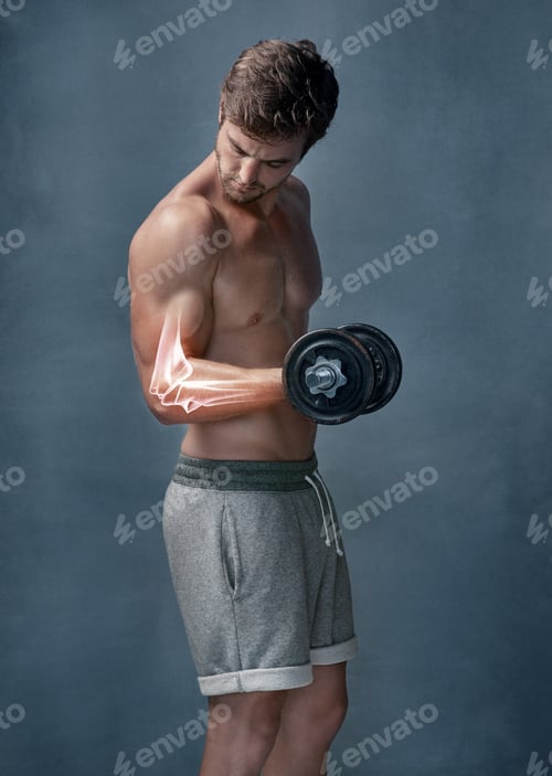 Preview: Shot of a focussed young man experiencing elbow strain while working out with weights in the studio