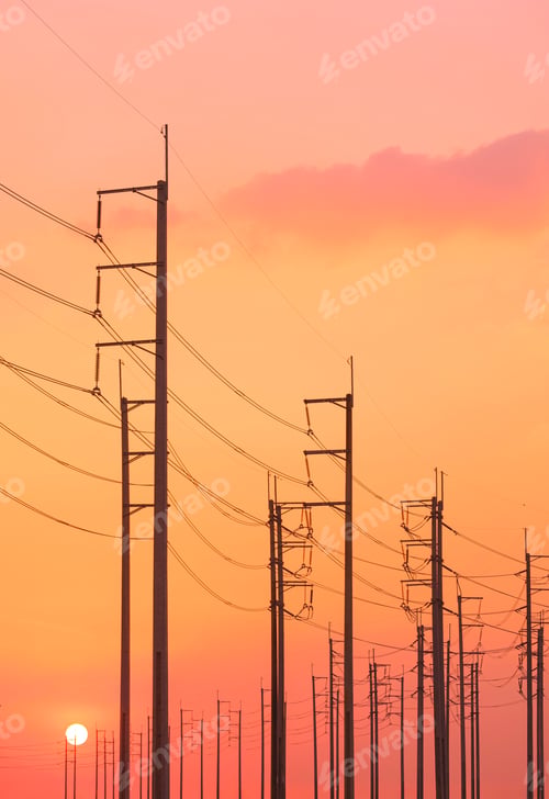 Preview: Silhouette row of electric poles with cable lines against colorful orange sunset sky in evening time