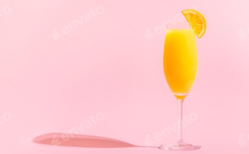 Preview: Bright Mimosa Cocktail with Orange Slice on Pink