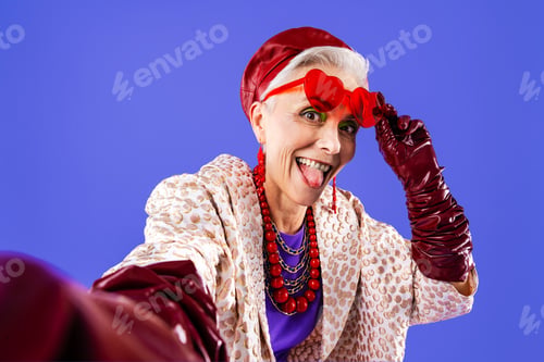 Preview: Happy and funny senior old woman on colorful background